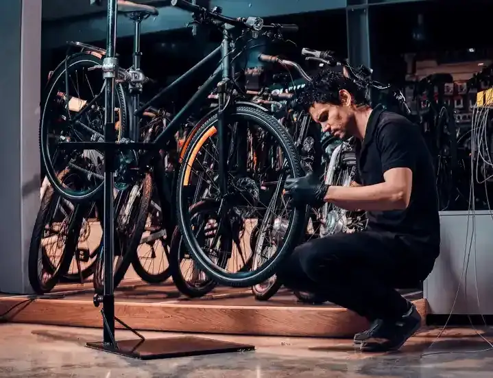 Experienced mechanic tuning a bicycle on a workshop stand