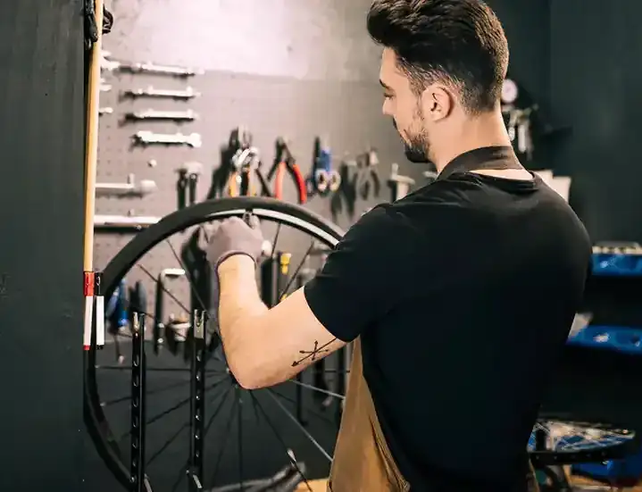 Mechanic adjusting the drivetrain on a bike at our workshop